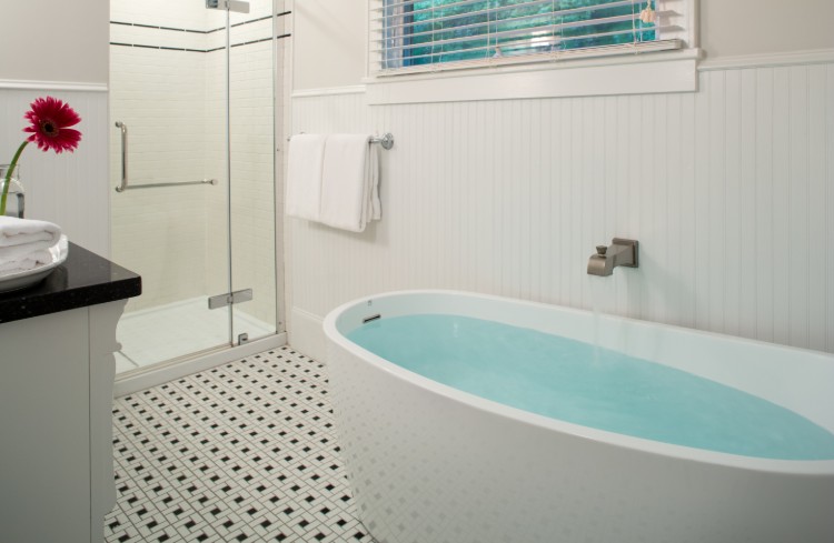 white tub with blue water and subway tile in the bathroom