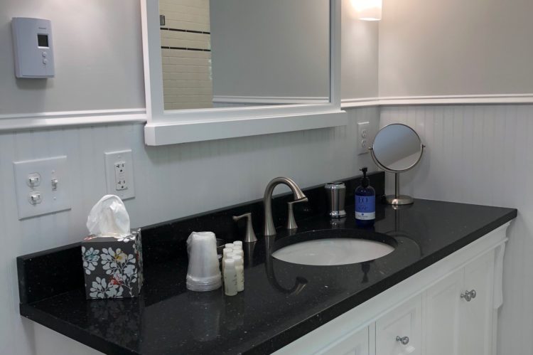 The bathroom includes a black vanity with a white sink.